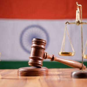 Concept of Indian justice system showing by using Judge Gavel, Balance scale on Indian flag as background.